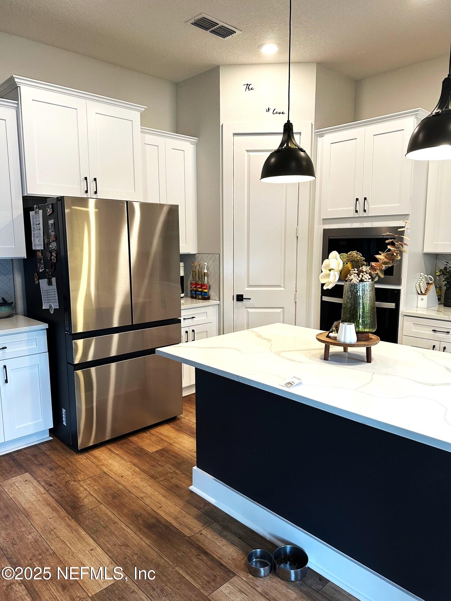36079 Pitch Lane Hilliard, FL 32046 - Photo 6 of 35 a kitchen with stainless steel appliances a refrigerator and a stove top oven