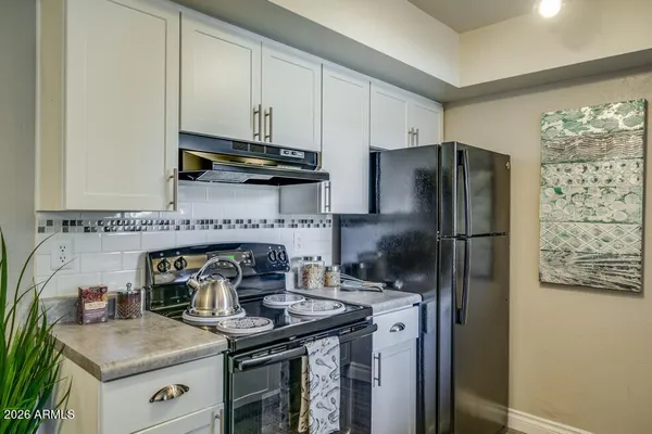 a kitchen with stainless steel appliances granite countertop a refrigerator and a stove