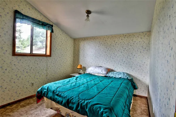 a bed sitting in a bedroom next to a window