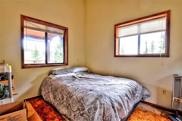 a bedroom with a bed and windows
