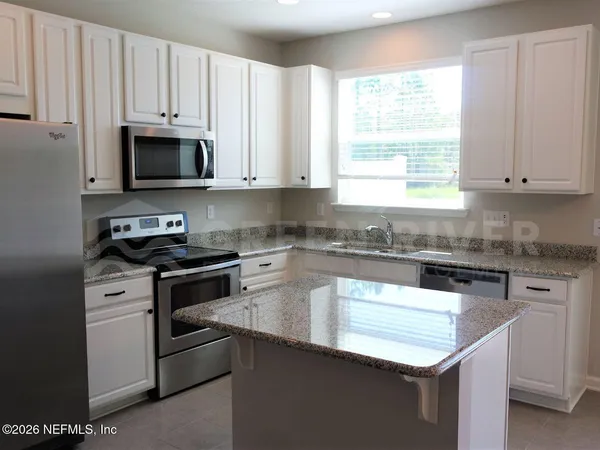 a spacious bathroom with a granite countertop sink a large mirror and a shower