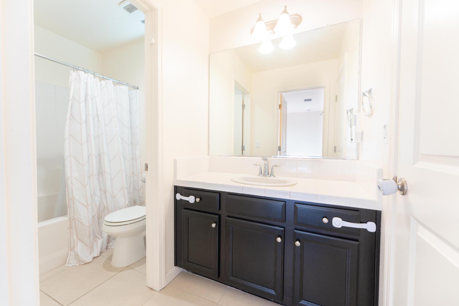 835 Fir Street Madera, CA 93636 - Photo 16 of 21 a bathroom with a double vanity sink toilet and a mirror