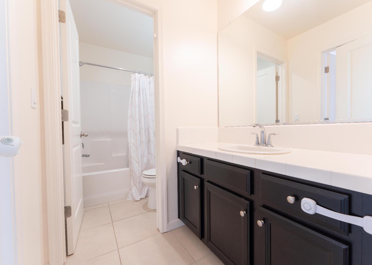 835 Fir Street Madera, CA 93636 - Photo 18 of 21 a bathroom with a double vanity sink and mirror with shower