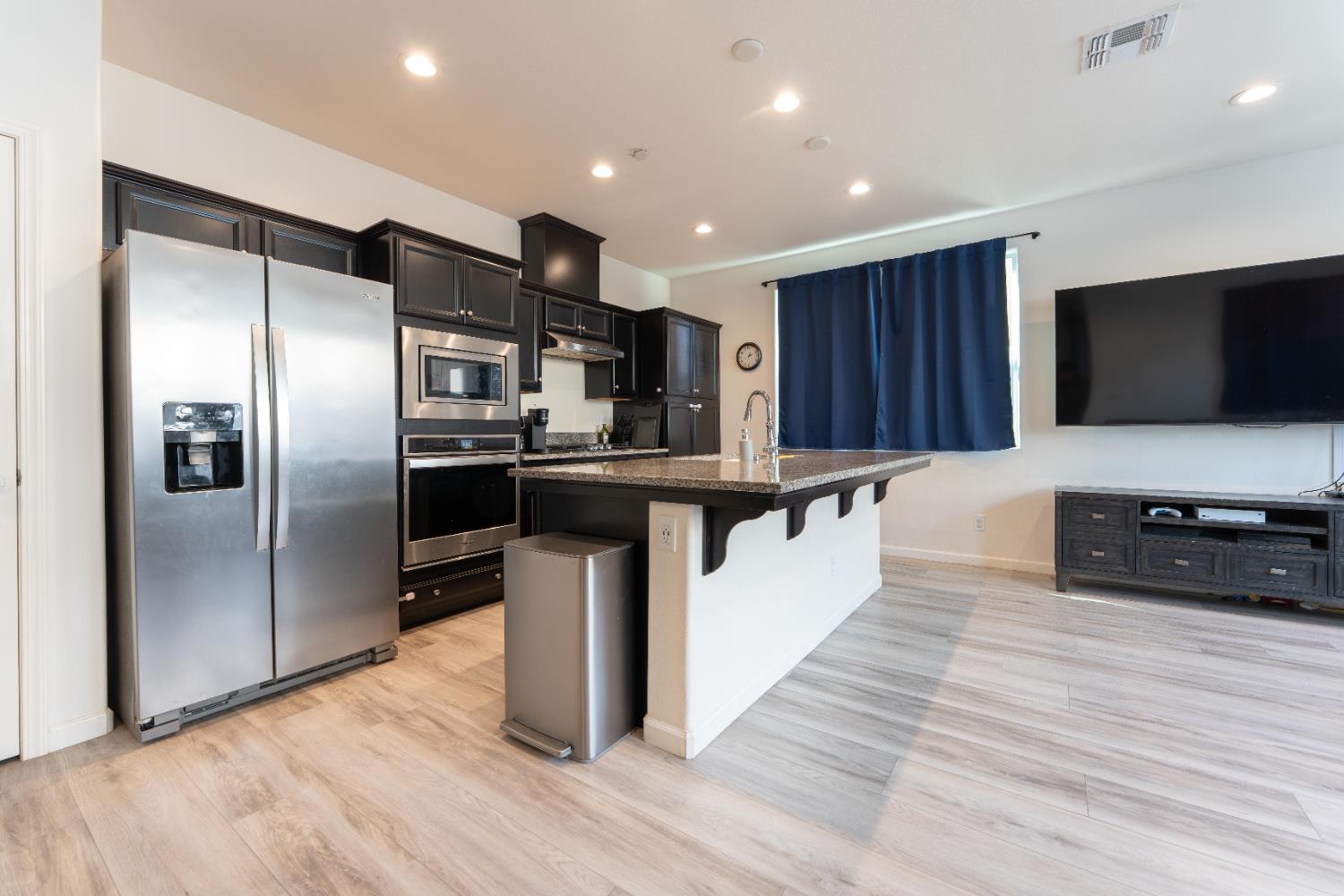 835 Fir Street Madera, CA 93636 - Photo 6 of 21 a kitchen with stainless steel appliances kitchen island granite countertop a stove top oven a sink and a microwave