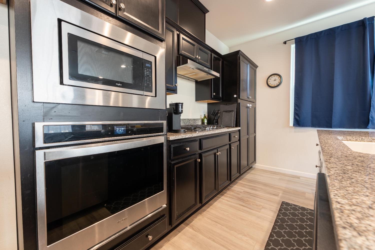 835 Fir Street Madera, CA 93636 - Photo 7 of 21 a kitchen with stainless steel appliances granite countertop a stove and a microwave