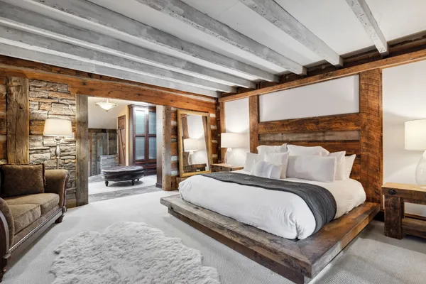 a bedroom with a bed couch and a large window with outer view