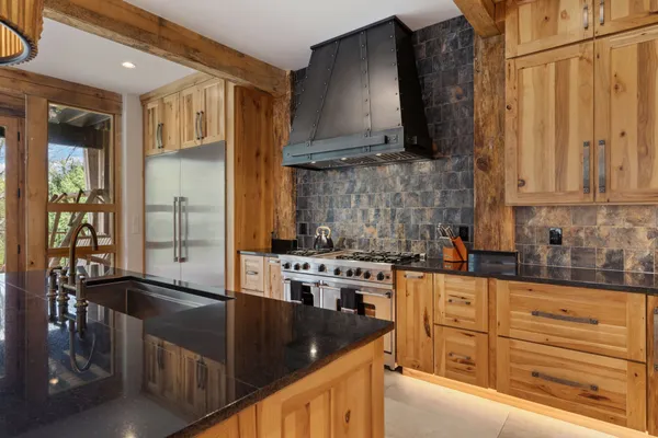 a kitchen with stainless steel appliances granite countertop a stove and more cabinets