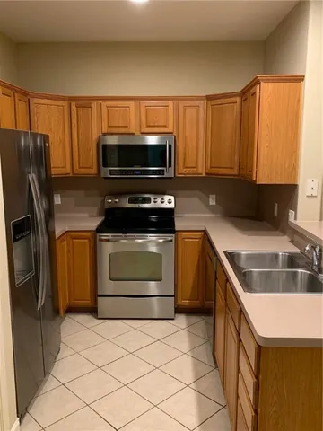 a kitchen with stainless steel appliances granite countertop a stove a microwave and a refrigerator