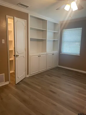 a view of an empty room with closet and a window