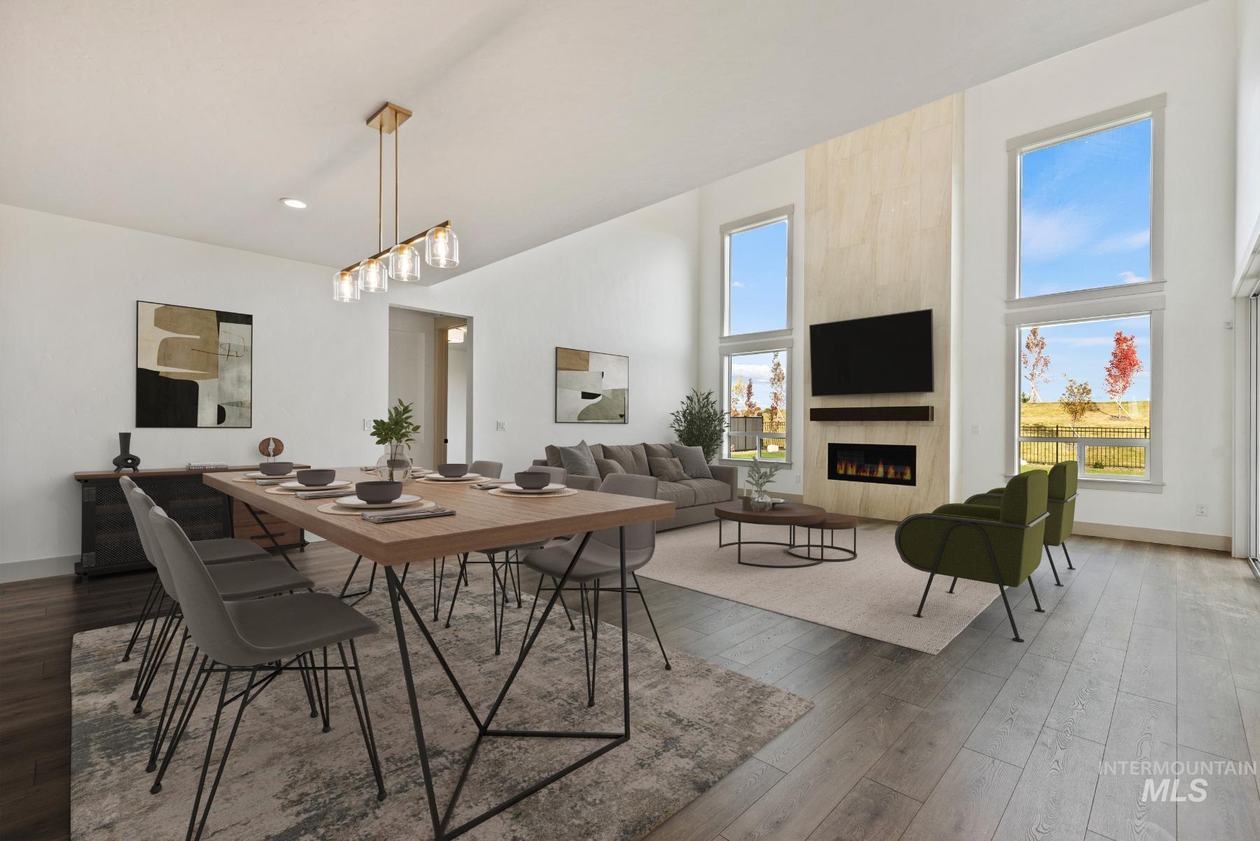 8482 West Graye Street, Unit ALPINE Meridian, ID 83646 - Photo 7 of 19 Dining space with a fireplace, dark wood-style flooring, and a high ceiling