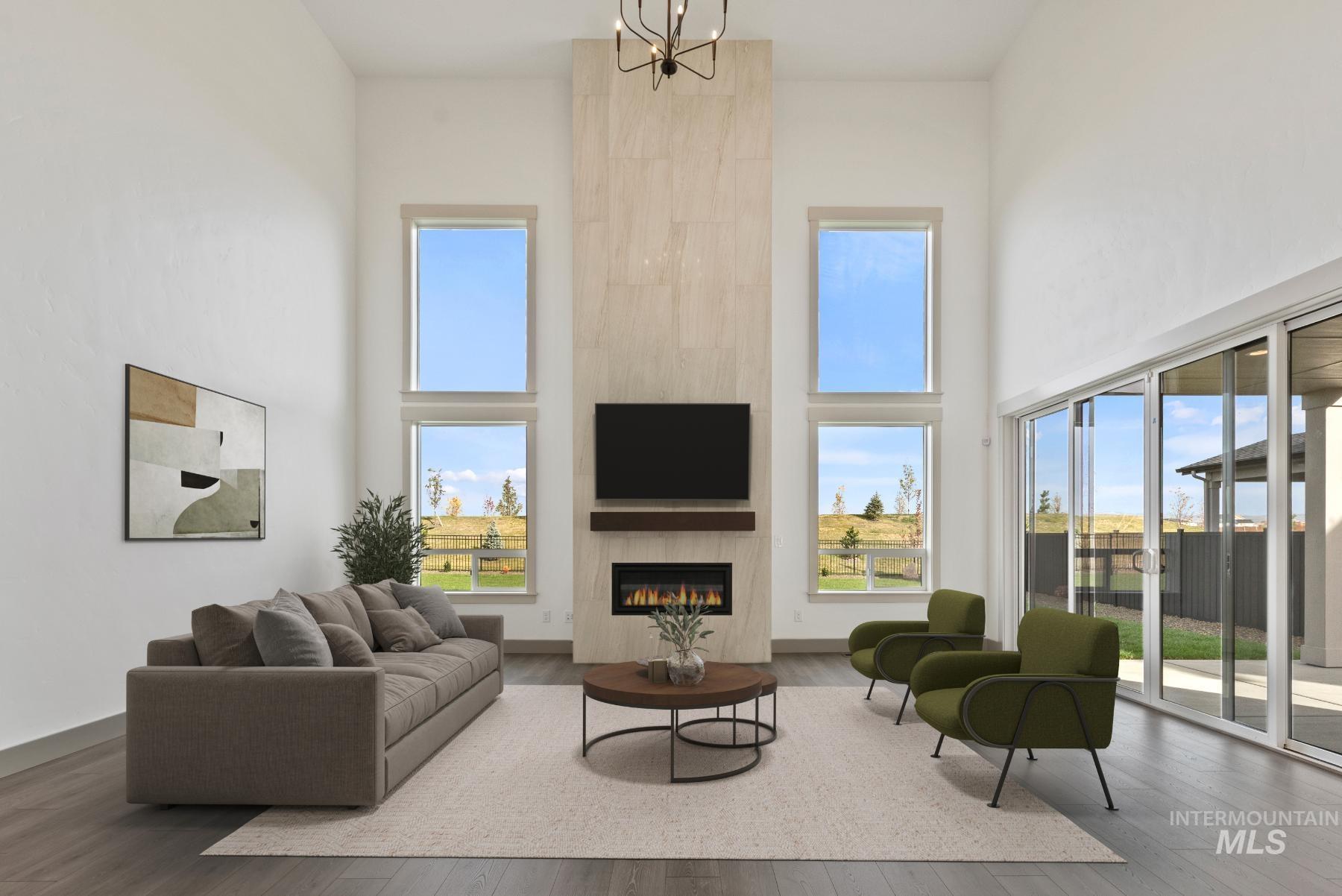 8482 West Graye Street, Unit ALPINE Meridian, ID 83646 - Photo 8 of 19 Living area featuring a towering ceiling, a tile fireplace, healthy amount of natural light, and hardwood / wood-style floors