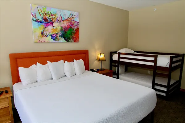 a bed sitting in a bedroom next to a painting on the wall