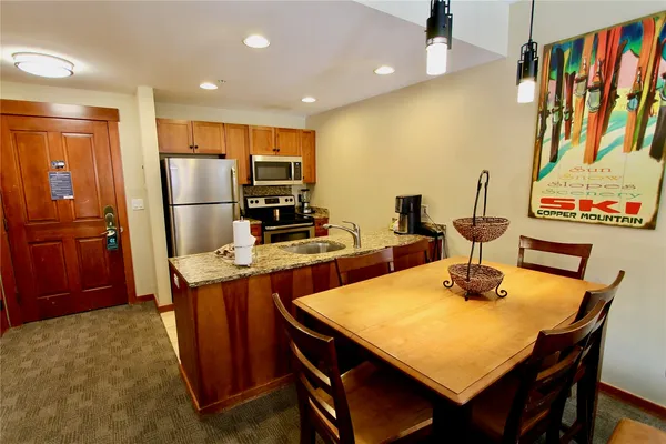 a kitchen with a table chairs and refrigerator