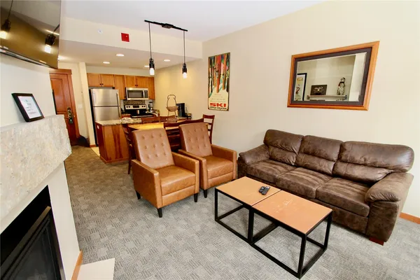 a living room with furniture and kitchen view