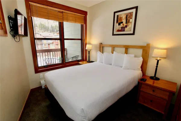 a large bed sitting in a bedroom next to a window