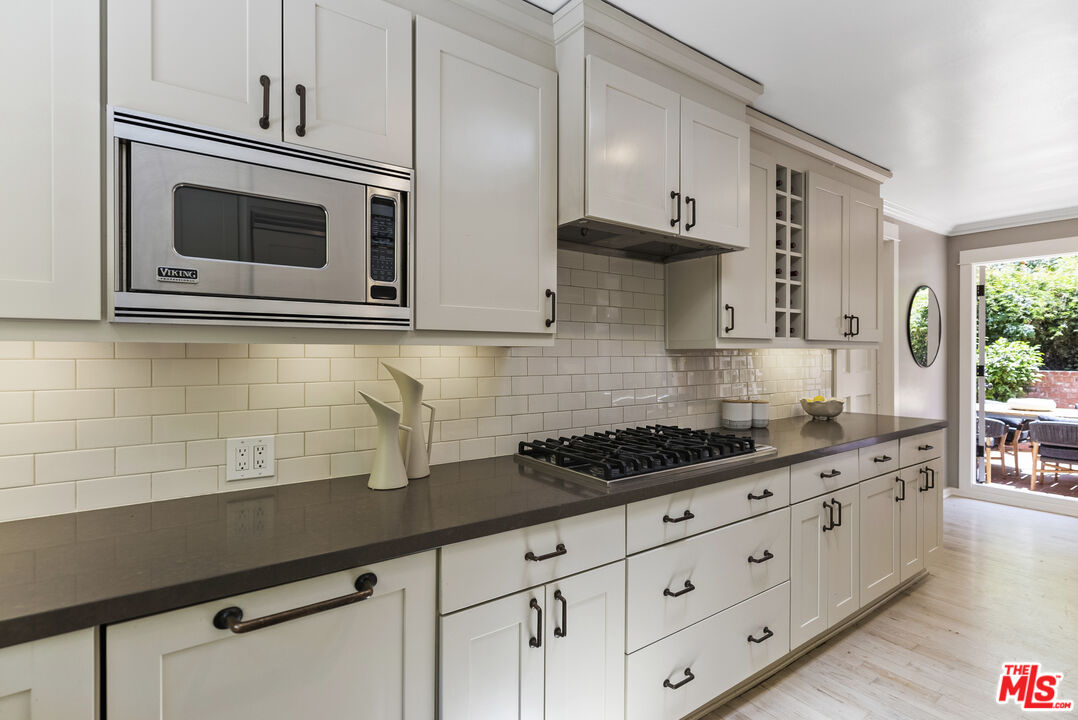 9520 Gloaming Drive Beverly Hills, CA 90210 - Photo 11 of 44 a kitchen with stainless steel appliances white cabinets and stove