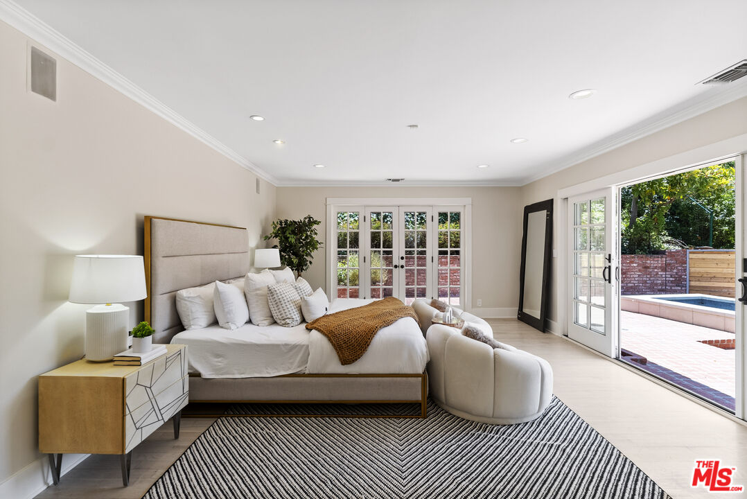 9520 Gloaming Drive Beverly Hills, CA 90210 - Photo 16 of 44 a bedroom with a large bed a couch and a large window