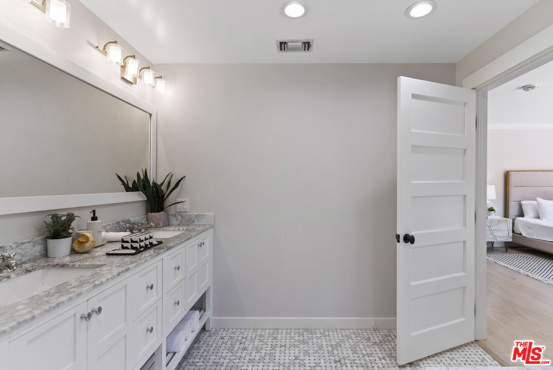 9520 Gloaming Drive Beverly Hills, CA 90210 - Photo 23 of 44 a bathroom with a granite countertop sink a mirror and shower