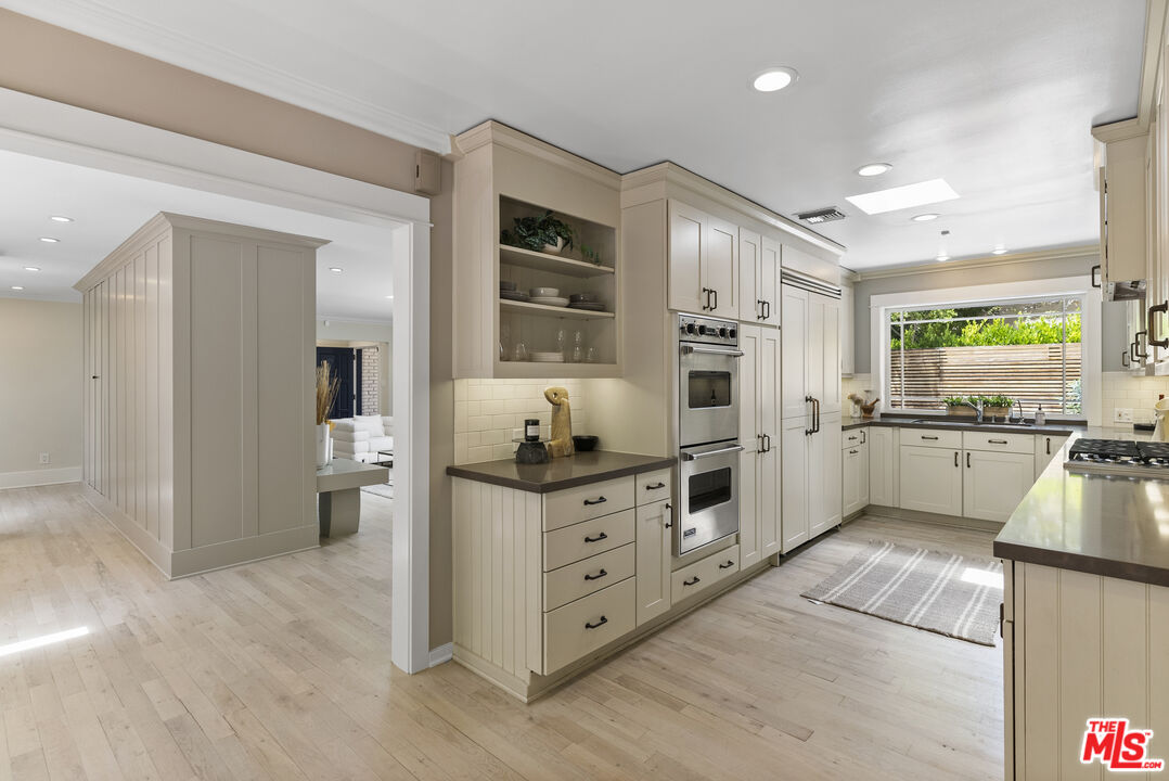 9520 Gloaming Drive Beverly Hills, CA 90210 - Photo 9 of 44 a kitchen with stainless steel appliances kitchen island granite countertop a stove refrigerator and cabinets