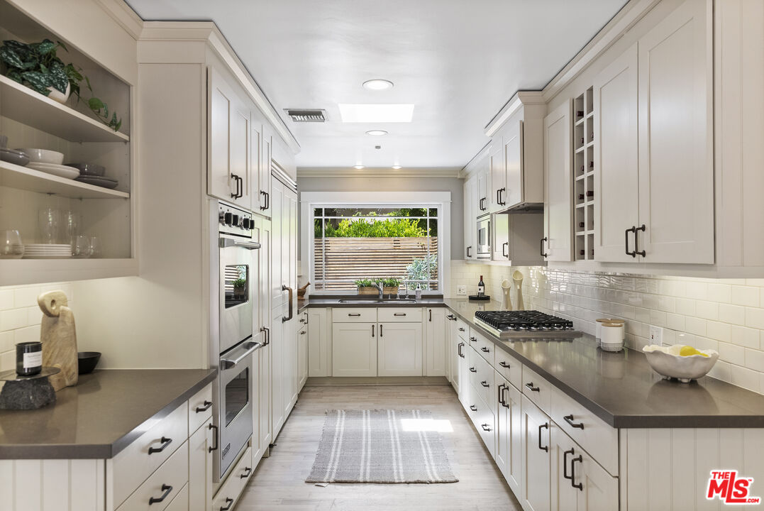 9520 Gloaming Drive Beverly Hills, CA 90210 - Photo 10 of 44 a kitchen with granite countertop a sink stove and cabinets