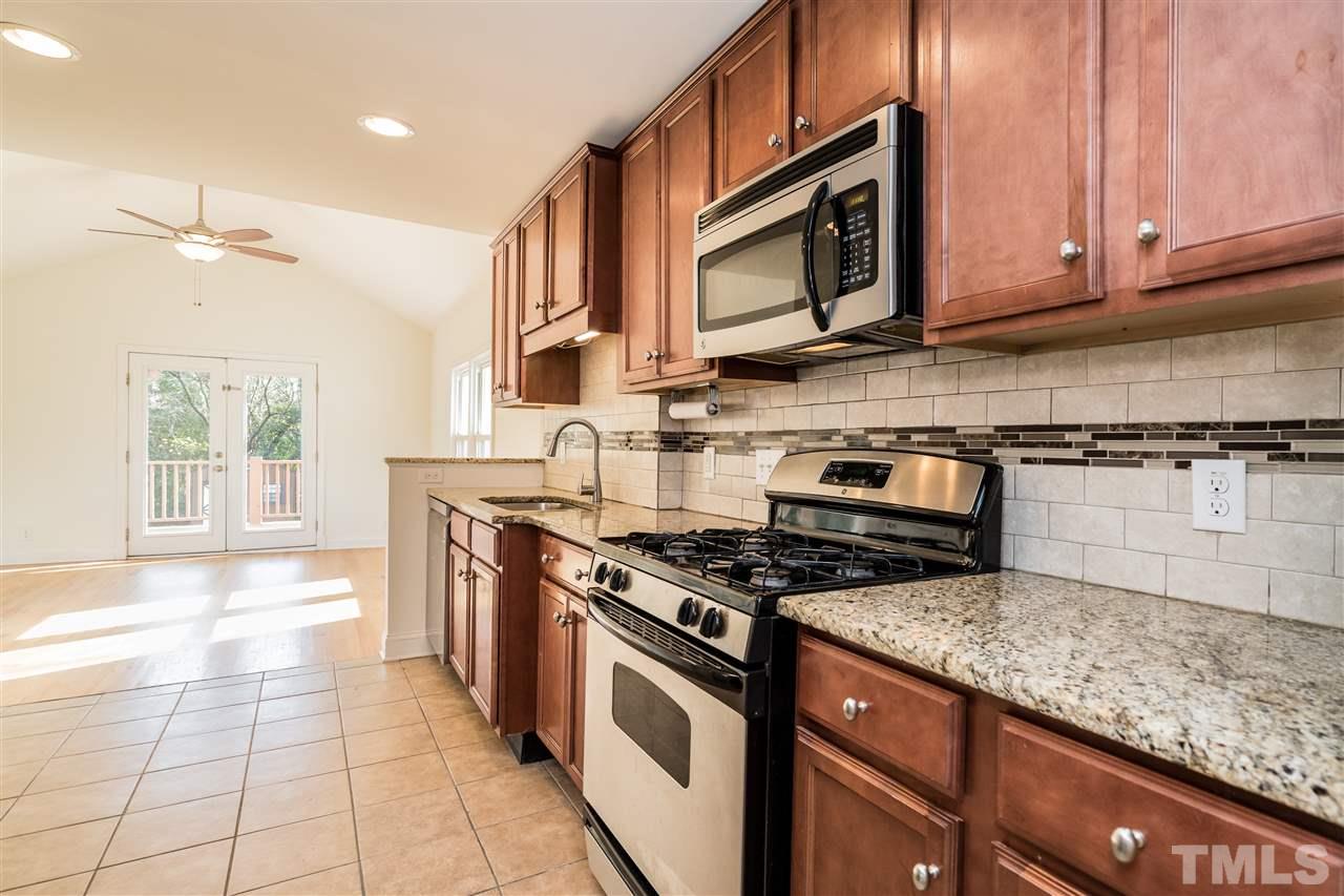 606 North King Charles Road Raleigh, NC 27610 - Photo 7 of 22 a kitchen with stainless steel appliances granite countertop a stove a sink and a microwave
