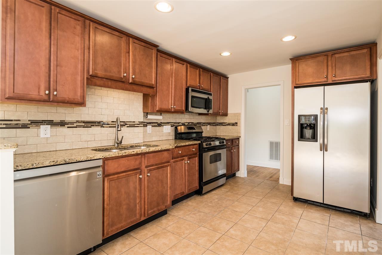 606 North King Charles Road Raleigh, NC 27610 - Photo 8 of 22 a kitchen with stainless steel appliances granite countertop a refrigerator sink and cabinets