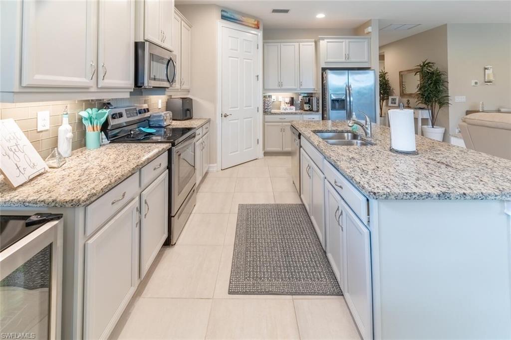 16366 Barclay Court Naples, FL 34110 - Photo 8 of 35 a kitchen with stainless steel appliances granite countertop a sink stove and refrigerator