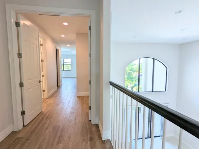 a view of a swimming pool with a lawn chairs under palm trees