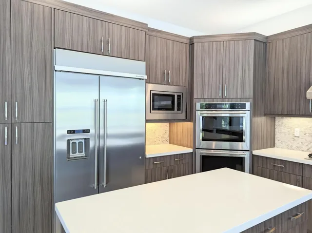 a kitchen with kitchen island a sink a stove and refrigerator