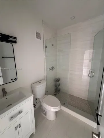 a white toilet sitting next to a bathroom sink