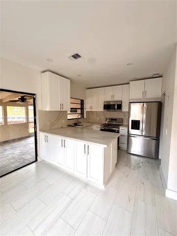 a kitchen with stainless steel appliances a refrigerator sink and microwave