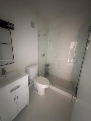 a white toilet sitting next to a bathroom sink and vanity