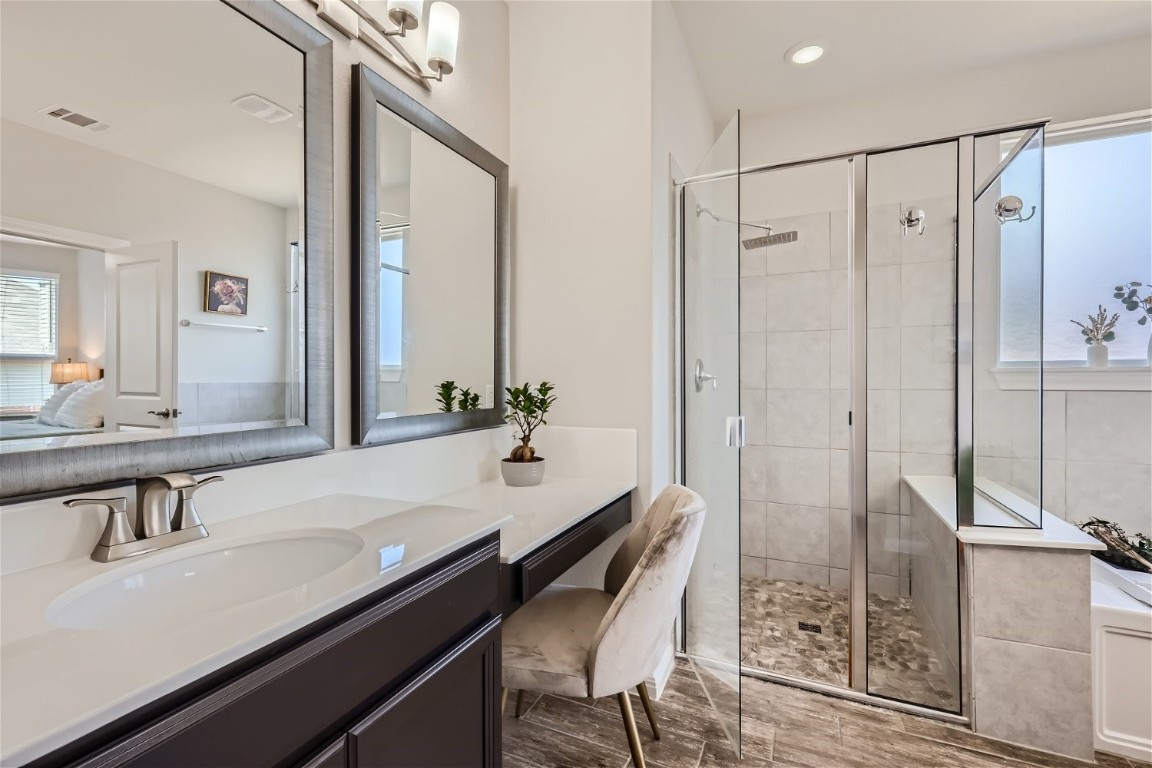 159 Bayberry Circle Buda, TX 78610 - Photo 19 of 29 a bathroom with a granite countertop sink a mirror and a shower