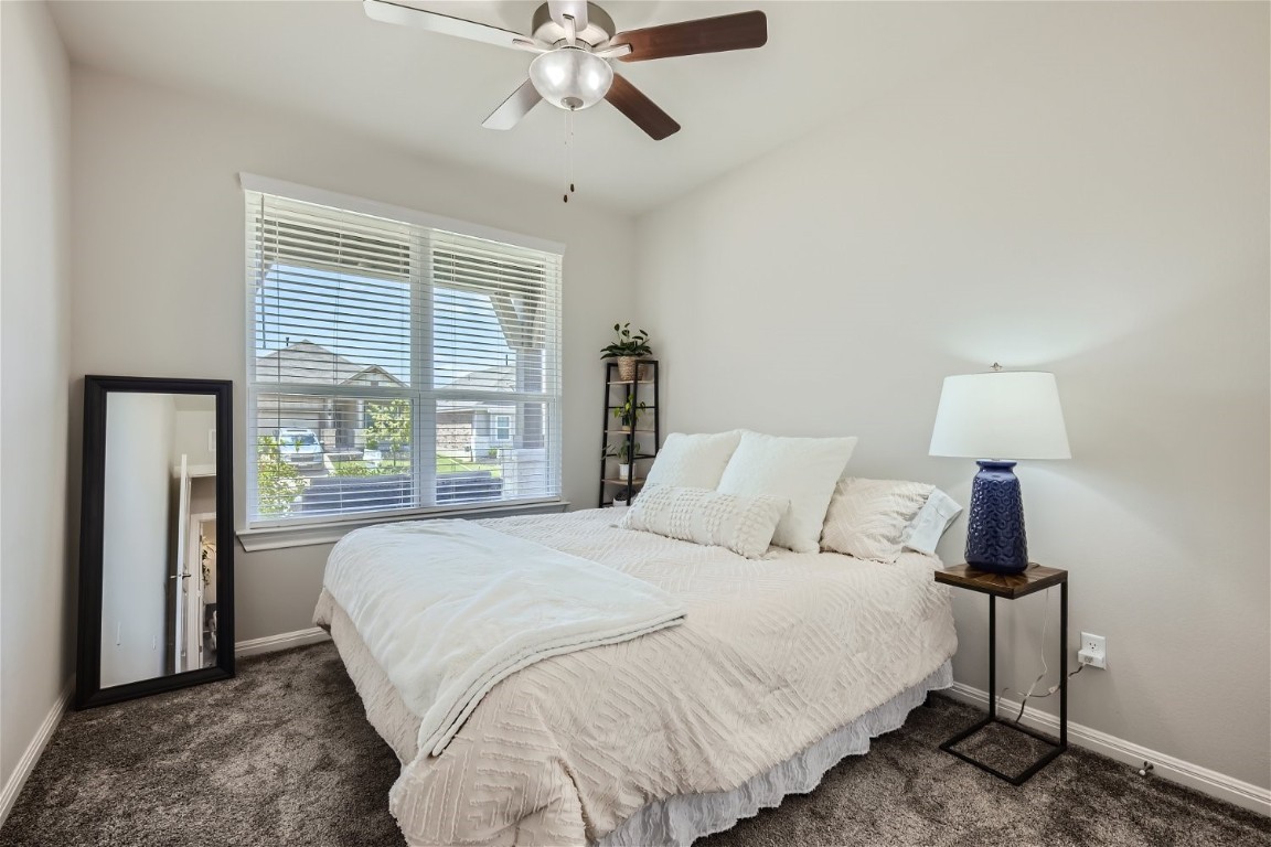 159 Bayberry Circle Buda, TX 78610 - Photo 21 of 29 a bedroom with a large bed and a chandelier