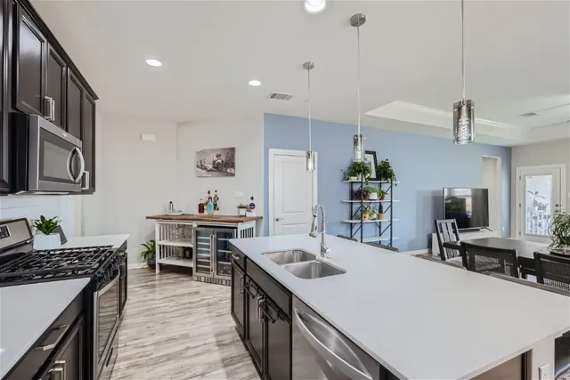 a kitchen with stainless steel appliances a sink a stove and a refrigerator