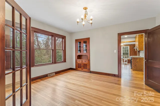 wooden floor chandelier and windows in a room