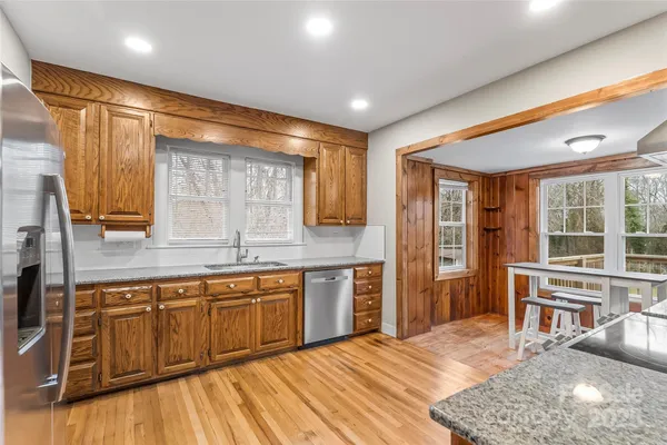 a kitchen with stainless steel appliances granite countertop a sink and wooden cabinets