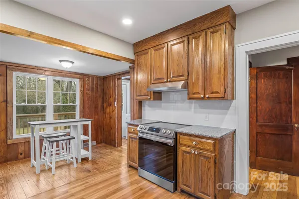 a kitchen with stainless steel appliances granite countertop wooden cabinets a stove a sink and a refrigerator