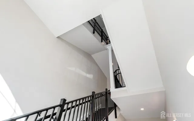 a view of staircase with railing and white walls