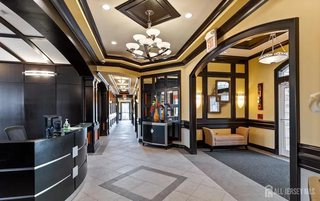 a view of hall way with furniture and a chandelier