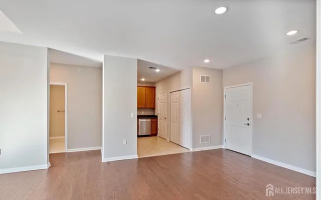 a view of an empty room with wooden floor