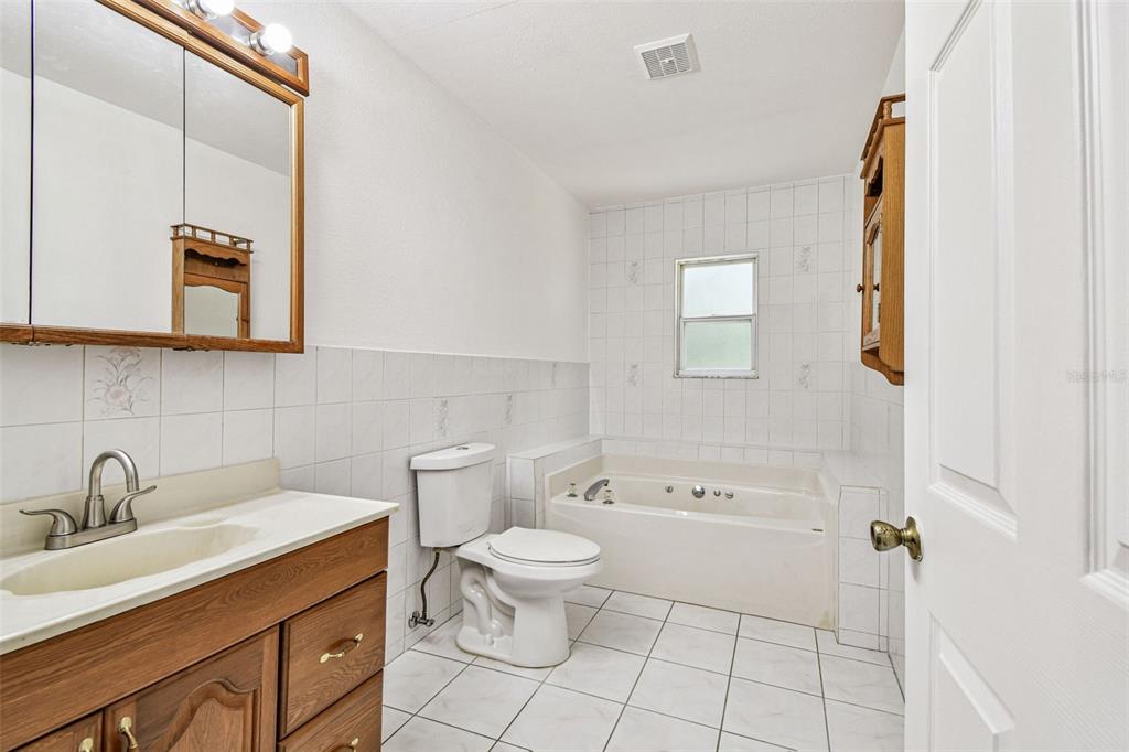 9741 Star Trail New Port Richey, FL 34654 - Photo 15 of 38 a bathroom with a toilet sink and mirror