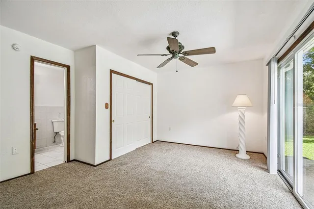an empty room with closet and a ceiling fan