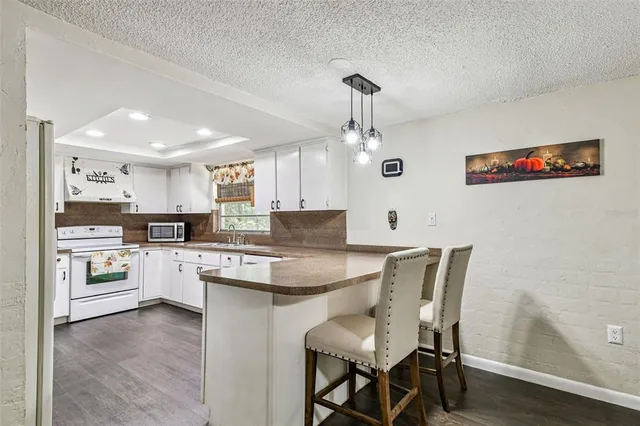 a kitchen with a dining table chairs stainless steel appliances and cabinets