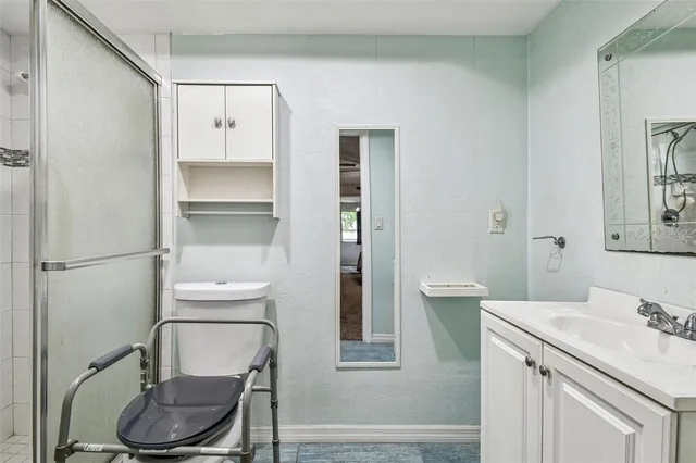 a bathroom with a granite countertop toilet sink and mirror