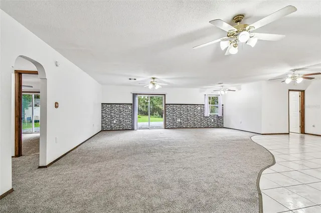 a view of a livingroom with a ceiling fan and window