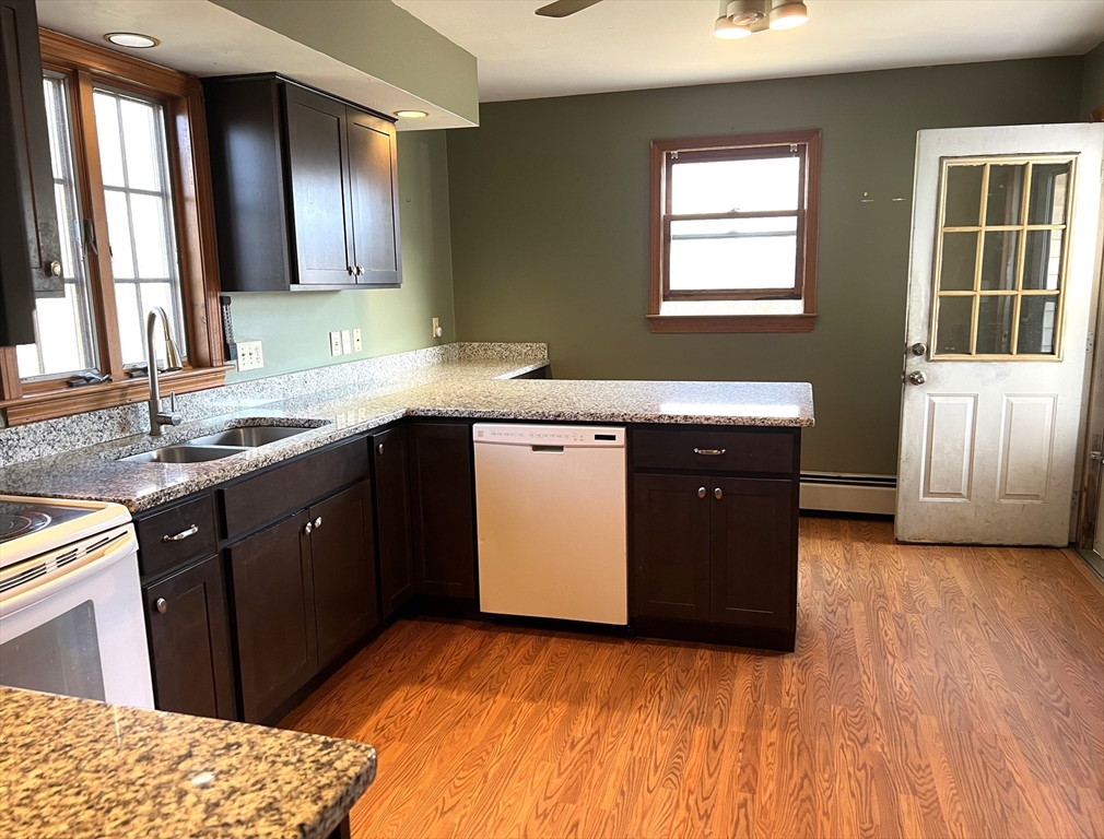 1261 G A R Highway Swansea, MA 02777 - Photo 11 of 25 a kitchen with a sink wooden cabinets and a window