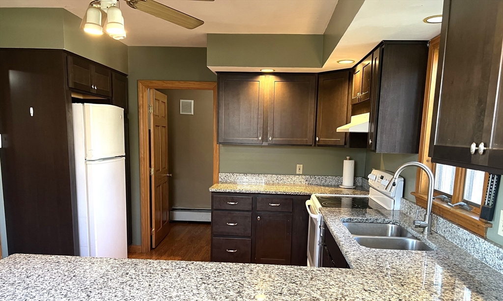 1261 G A R Highway Swansea, MA 02777 - Photo 12 of 25 a kitchen with granite countertop a sink cabinets and stainless steel appliances
