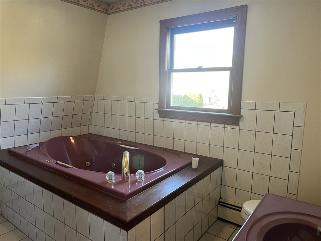 1261 G A R Highway Swansea, MA 02777 - Photo 24 of 25 a bath tub sitting in a bathroom next to a window