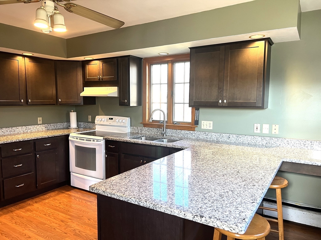 1261 G A R Highway Swansea, MA 02777 - Photo 10 of 25 a kitchen with stainless steel appliances granite countertop wooden cabinets a stove top oven a sink and dishwasher